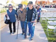  ??  ?? Bob Martinez, right, a Vietnam War veteran, walks with World War II veteran Andrew “Jack” Hulette and Hulette’s daughter, Linda Apodaca, after Saturday’s Veterans Day ceremony in Albuquerqu­e. Hulette served as a tail gunner with the U.S. Army Air Corps.