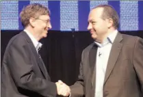  ?? ROBERT SORBO / AFP / GETTY IMAGES ?? Bill Gates, left, shakes hands with Rob Glaser yesterday.