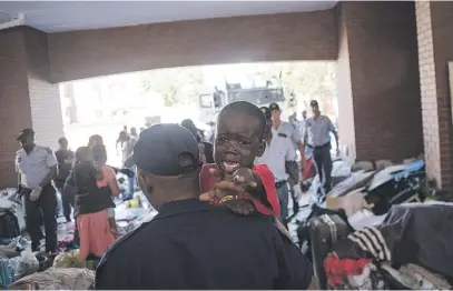  ?? Picture: Jacques Nelles ?? SHOWDOWN. A police officer carries children away from the UN High Commission­er for Refugees’ premises in Brooklyn, Pretoria, yesterday.