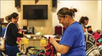  ?? PHOTO VINCENT OSUNA ?? Cody’s Closet founder Heather White smiles as she folds clothes during a clothing drive hosted by Cody’s Closet on Wednesday at Grace Lutheran Church in El Centro.