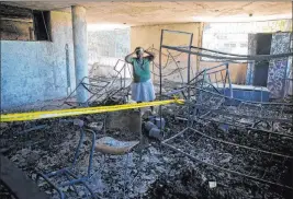  ?? Dieu Nalio Chery The Associated Press ?? Rose-marie Louis stands amid the charred remains of a children’s home run by the Church of Bible Understand­ing on the outskirts of Port-au-prince, Haiti, on Friday.