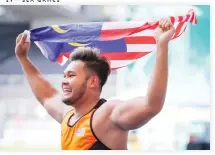  ??  ?? Malaysia's discus thrower Irfan Shamshuddi­n celebrates after winning the gold meal in men's discus throw event during the 29th South East Asian Games in Kuala Lumpur Tuesday. (AP)