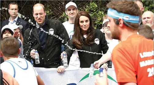  ?? CHRIS JACKSON VIA AP PHOTO ?? AWAS KENA: Pangeran William mengelak dari air yang disemprotk­an salah satu peserta London Marathon, sementara istrinya, Duchess of Cambridge Kate Middleton, melihat dengan tidak senang.