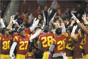  ?? Michael Macor / The Chronicle ?? USC players celebrate their victory over Stanford in the Pac-12 title game. The Trojans were not chosen for the college playoff, the second time in four years the Pac-12 has been left out.