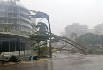  ?? WILFREDO LEE/THE ASSOCIATED PRESS ?? Palm trees lie strewn across a road in Miami Beach as Irma pelts the east coast with torrential rains and wind.