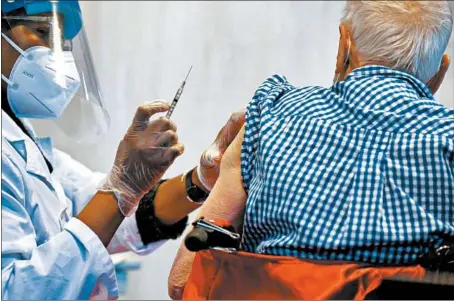  ?? ANTONIO PEREZ/CHICAGO TRIBUNE ?? Dino Franceschi­na receives his COVID-19 vaccine at Caledonia Senior Living and Memory Care in North Riverside on Jan. 12.