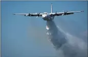 ?? RFS ?? In this undated photo released from the Rural Fire Service, a C-130 Hercules plane called “Thor” drops water during a flight in Australia.