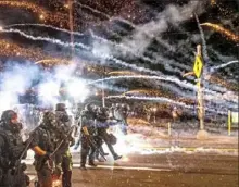  ?? Noah Berger/ Associated Press ?? Police use chemical irritants and crowd control munitions to disperse protesters Saturday in Portland, Ore.