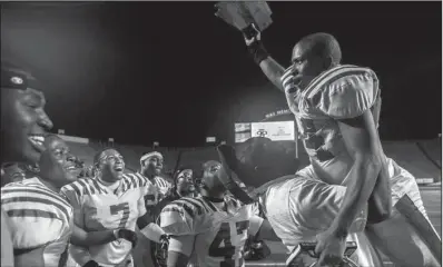  ?? Arkansas Democrat-Gazette/MELISSA SUE GERRITS ?? Pine Bluff linebacker Malik Isiah (right) celebrates with teammates after the Zebras defeated Benton 51-10 on Friday night in the Class 6A championsh­ip game at War Memorial Stadium in Little Rock.