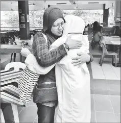  ??  ?? Nur Syazwani hugs her mother after the registrati­on at Kolej Tunku Kurshiah.