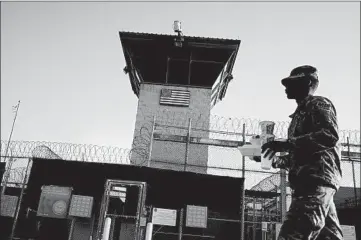  ?? RAMON ESPINOSA/AP 2018 ?? A person walks past a detention center on the U.S. base at Guantanamo Bay, Cuba.