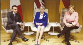  ??  ?? Britain’s PM Theresa May flanked by French President Emmanuel Macron and German Chancellor Angela Merkel at their trilateral meeting at the EU leaders summit in Brussels on Thursday