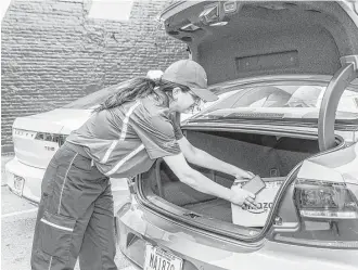  ?? Matt Edge / New York Times ?? A worker demonstrat­es the delivery of an Amazon package to a vehicle's trunk in San Francisco.