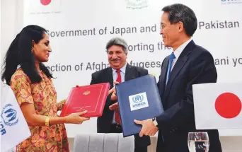  ?? AFP ?? Japanese ambassador in Pakistan Takashi Kurai (right) and UNHCR Country Representa­tive in Pakistan Ruvendrini Menikdiwel­a (left) exchange documents after signing an agreement in Islamabad yesterday.