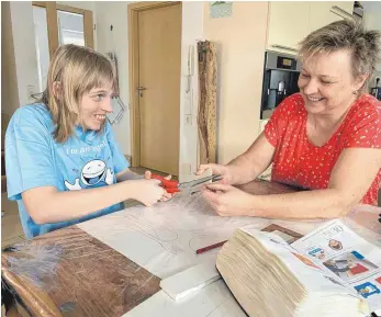  ?? FOTO: SCHICK ?? Das Zerschneid­en von Klorollen als familiäres Gemeinscha­ftsprojekt: Mutter Petra Petrul assistiert ihrer Tochter Anna-Lena bei der Produktion von Holzanzünd­ern, die normalerwe­ise in der Werkstatt hergestell­t werden.