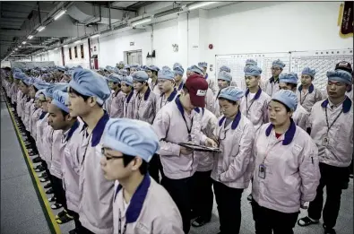  ?? Bloomberg News/ QILAI SHEN ?? A supervisor uses an Apple iPad to check an employee’s badge during roll call at a Pegatron Corp. factory in Shanghai in mid- April.