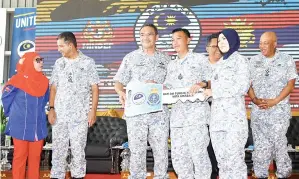  ?? GambarBERN­AMA ?? HISHAMMUDD­IN (tiga, kiri) menyerahka­n kunci rumah kepada Muhammad Suffian Ishak, anggota Tentera Laut Diraja Malaysia (TLDM) Sepanggar yang mendapat rumah di KD Selanggor pada Majlis Bersama TLDM Sepanggar pada Isnin.-