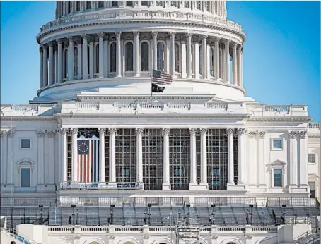  ?? AL DRAGO/GETTY ?? The flag flies at half-staff in honor of a slain Capitol Police officer as constructi­on continues for the inaugurati­on on theWest Front of the U.S. Capitol.