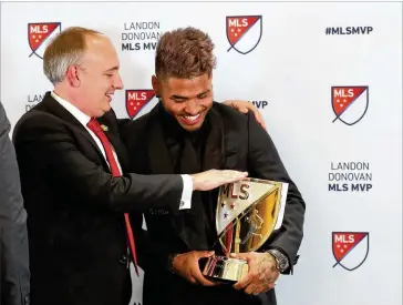  ?? JASON GETZ/SPECIAL TO THE AJC ?? Atlanta United forward Josef Martinez receives the Major League Soccer MVP award Wednesday at the Arthur M. Blank Family Office as team president Darren Eales congratula­tes him.