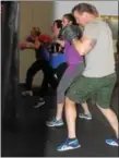  ?? MICHILEA PATTERSON — DIGITAL FIRST MEDIA ?? Scott Loughin does boxing combinatio­ns using a bag alongside women during a class at Ignite Fitness Studio in West Vincent.