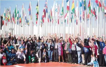  ?? —AFP photos ?? MARRAKECH, Morocco: Members of Internatio­nal delegation­s pose for a group photo outside the COP22 climate conference on yesterday, in Marrakesh.