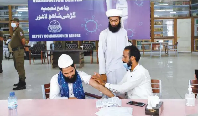  ?? Associated Press ?? ↑ A student receives the Convidecia shot at a vaccinatio­n centre, set up in Jamia Naeemia in Lahore, on Monday.