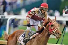  ?? AP PHOTO/CHARLIE NEIBERGALL ?? Sonny Leon celebrates after riding Rich Strike past the finish line to win Saturday’s 148th running of the Kentucky Derby at Churchill Downs.