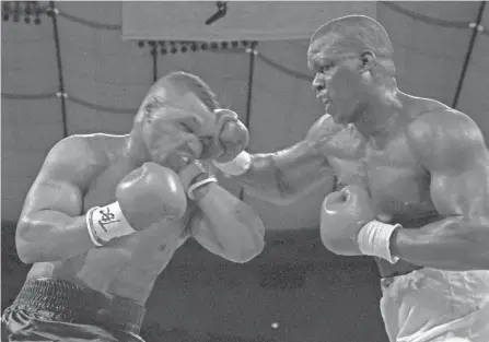  ?? AP ?? In this Feb. 11, 1990, file photo, James “Buster” Douglas, right, hits Mike Tyson with a hard right in the face during their world heavyweigh­t title bout at the Tokyo Dome in Tokyo.