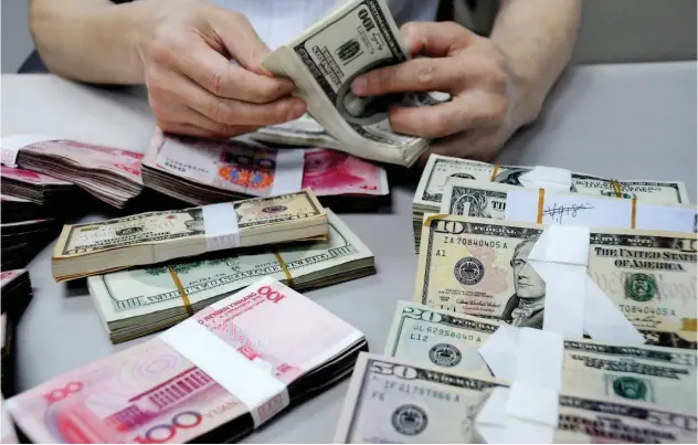  ??  ?? ↑ The drop in the yuan to a low of 7.0240 per dollar triggered selling in regional stock markets.