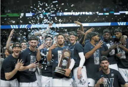  ?? CHARLES KRUPA — THE ASSOCIATED PRESS ?? Villanova’s Jalen Brunson holds the trophy as he celebrates with teammates after their win over Texas Tech in an NCAA men’s college basketball tournament regional final Sunday in Boston. Villanova won 71-59 to advance to the Final Four.