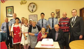  ??  ?? Joan Barry and Michael O’Sullivan cutting the cake at the annual Senior Citizens Christmas party watched on by Mallow Gardai, who sponsored the event, Councillor Gearòid Murphy and Social Services staff. Photos: Eugene Cosgrove