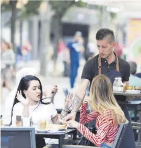  ?? A. J. GONZÁLEZ ?? Un camarero sirve a dos jóvenes en una cafetería cordobesa.