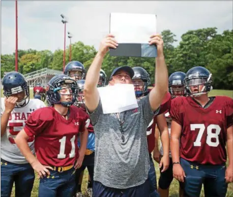  ?? DIGITAL FIRST MEDIA FILE ?? At his first training camp as Cardinal O’Hara’s head coach in 2015, B.J. Hogan looks over his very special playcharts.