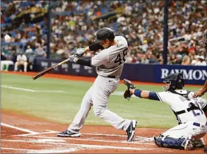  ?? Scott Audette / Associated Press ?? The New York Yankees’ Anthony Rizzo, left, hits a sacrifice fly to center in front of Tampa Bay Rays catcher Francisco Mejia, second from right, during the first inning on Saturday.