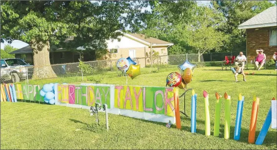  ?? (NWA Democrat-Gazette/Susan Holland) ?? Colorful hand-painted signs lined up across the front lawn at the Crose home May 6 extended 16th birthday wishes to Taylor Crose. The signs welcomed participan­ts as they drove past in Taylor’s special birthday parade.