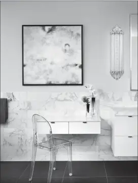  ?? Special to the Herald ?? The shimmering glass sconce from Hudson Valley Lighting lends twentieth century charm to a modern bathroom.