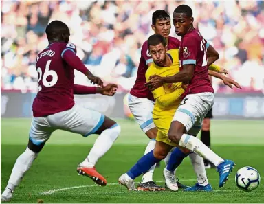  ?? — AFP ?? Nowhere to go: Chelsea’s Eden Hazard (in yellow) trying to get past West Ham players during the Premier League match at the London Stadium yesterday.