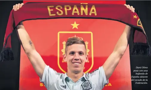  ??  ?? Dani Olmo posa con una bufanda de España delante del escudo de la Federación.
