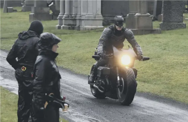  ?? PICTURE: ANDREW MILLIGAN/PA ?? 0 A motorcycli­st dressed as Batman during filming at the Glasgow Necropolis for the surperhero franchise earlier this year