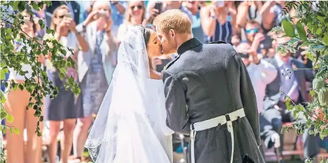  ?? FOTO: DPA ?? Der erste öffentlich­e Kuss von Prinz Harry und Meghan, der Herzogin von Sussex, vor der St.-Georgs-Kapelle auf Schloss Windsor. Rund zwei Sekunden soll der Kuss gedauert haben und damit ähnlich lang wie der von Prinz William und Kate (1,8 Sekunden).