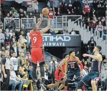  ?? NICK WASS THE ASSOCIATED PRESS ?? Raptors’ Serge Ibaka shoots late in double OT over Wizards’ Otto Porter Jr. and Tomas Satoransky on Sunday.