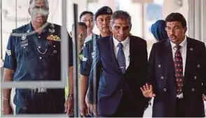  ??  ?? A combo picture showing Datuk Seri Najib Razak and Tan Sri Dr Mohd Irwan Serigar Abdullah being led out of the Sessions Court in Kuala Lumpur yesterday.