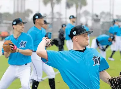  ?? JOHN MCCALL/SUN SENTINEL PHOTOS ?? Miami Marlins pitcher Nick Neidert warms up on the first day of spring training at the team’s facility in Jupiter on Wednesday.