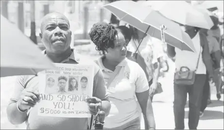  ??  ?? Chair of the South Georgetown Branch of the Guyana Teachers’ Union (GTU) Kirwyn Mars carries a placard stating that the “CAPE and CSEC top students back the teachers’ strike and so should you” at yesterday’s protest action in front of the Ministry of the Presidency. The placard includes a headline from the Sunday Stabroek of August 19.