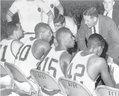  ?? AP FILE ?? During the 1963 NCAA title game, Loyola coach George Ireland offers instructio­n to his team during the Ramblers’ overtime victory over Cincinnati in Louisville, Ky. Seven black players started the game.