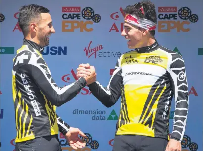  ?? Picture: AFP ?? TOGETHERNE­SS. German Manuel Fumic and Brazilian team-mate Henrique Avancini celebrate on the podium after winning the prologue of the Cape Epic mountain bike stage yesterday.