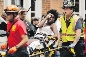  ?? — GETTY FILES ?? Rescue workers attend to victims after a car plowed through a group of protesters in Charlottes­ville, Va. An Ohio man was charged with murder in relation to the incident.