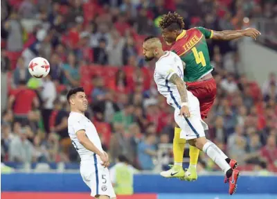  ?? — AFP ?? Cameroon’s defender Adolphe Teikeu (R) heads the ball with Chile’s midfielder Arturo Vidal next to Chile’s midfielder Francisco Silva (L) during the 2017 Confederat­ions Cup Group B match at the Spartak Stadium in Moscow.