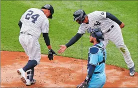  ?? KATHY WILLENS/AP PHOTO ?? The Yankees’ Gary Sanchez (24) greets Gleyber Torres at the plate after hitting a tworun home run during the second inning of Thursday’s season-opener against Toronto at Yankee Stadium. Toronto catcher Danny Jansen watches the pair. The Blue Jays won in 10 innings, 3-2.