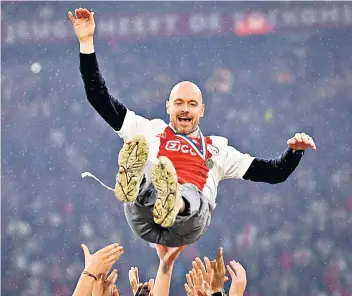  ?? ?? Winning habit: Erik ten Hag is thrown into the air during celebratio­ns after guiding Ajax to the Dutch title on Wednesday night